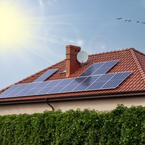 Renewable clean green energy saving efficient photovoltaic solar panels on house roof over blue sky.